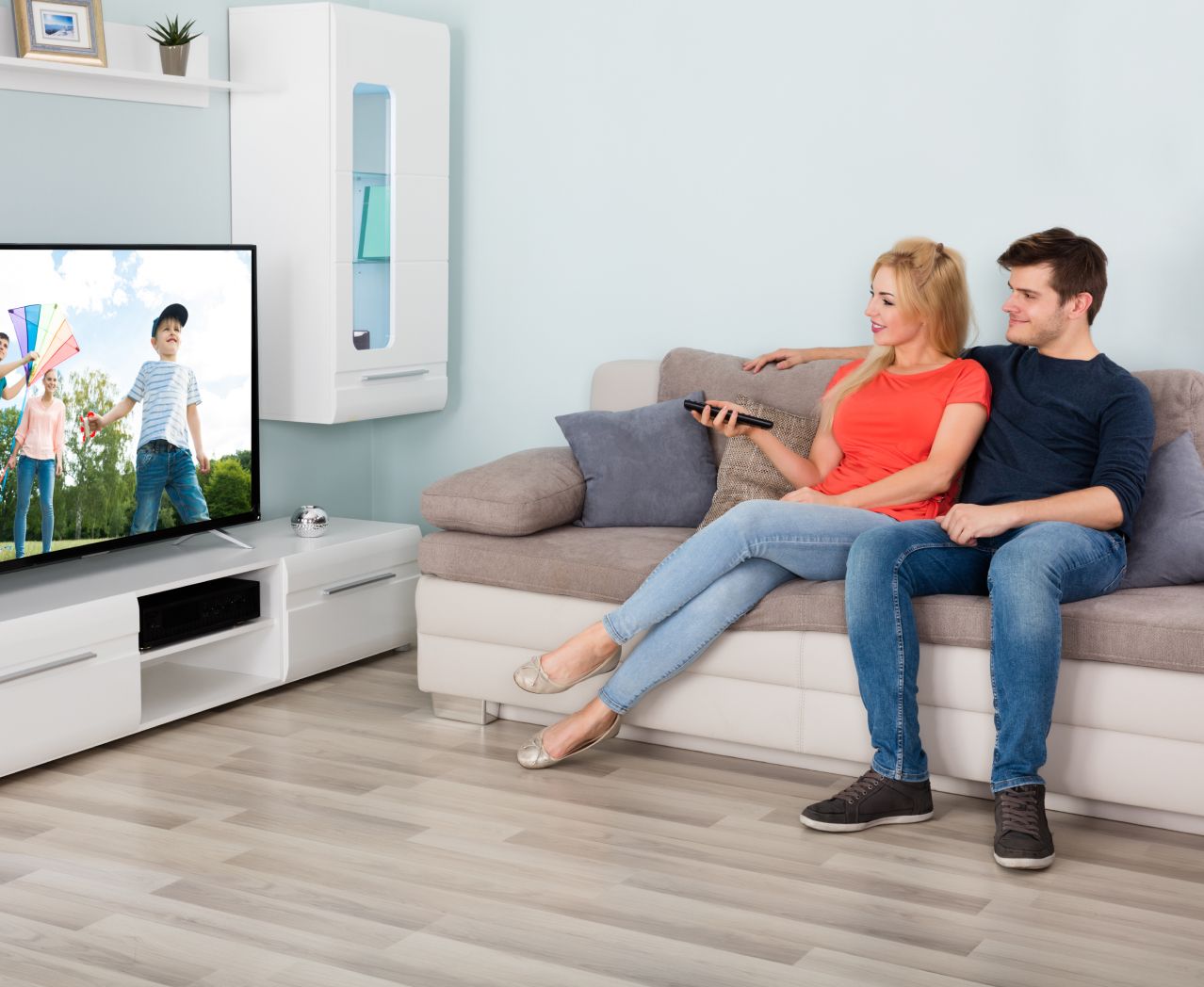 Paar sitzt vor dem Fernseher auf der Couch